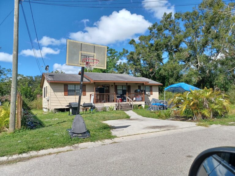 A house with a basketball hoop out front.