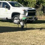 A drone on the ground near a truck with Clarke branding.