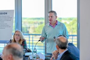 Jon Lewis gesticulating while speaking.