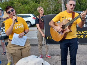 One demonstrator sings while another plays guitar.