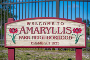 Sign that reads "Welcome to Amaryllis Park Neighborhood Established 1925" with amaryllis flower illustrations.