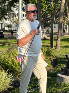 Tom Edwards outside speaking into a microphone.
