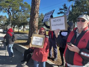 Demonstrators hold signs that read "Ziegler ist eine Ziege" and "NO ICE in schools!"