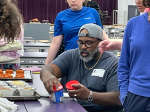 Chef G handles ingredients in a school cafeteria.