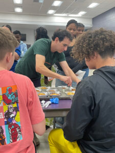 Andrew Grossman serves food in a school cafeteria.