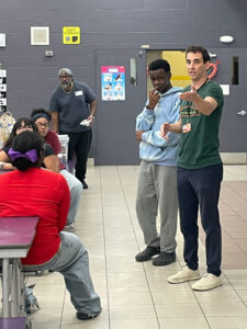 Andrew Grossman speaks with in a school cafeteria.