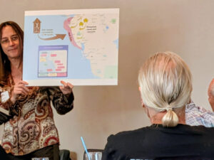 Kelly Franklin holds up a presentation slide with a map of the Sarasota area.