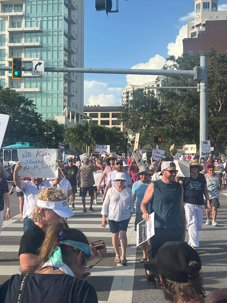 A crowd of demonstrators packs a downtown street carrying sides with messages like "No king allowed!!! In U.S.A."