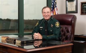 Grady Judd smiling while seated at his desk.