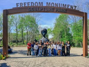 Students pose for a photo at the entrance to the Freedom Monument Sculpture Park.