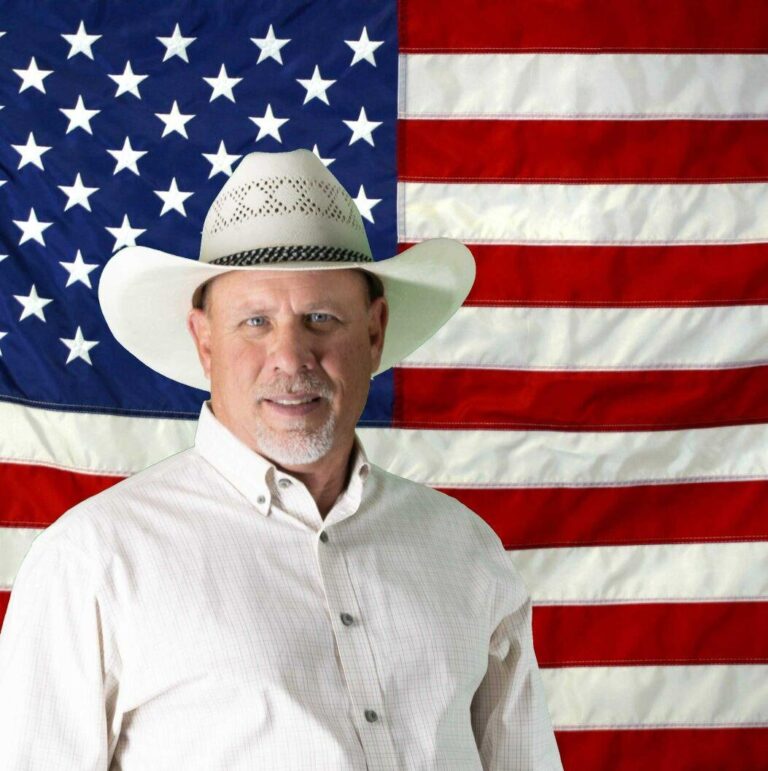 Ed Ference in front of a U.S. flag.