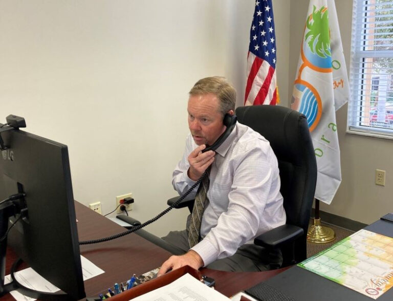 Gene Brown talking on the phone in his office.