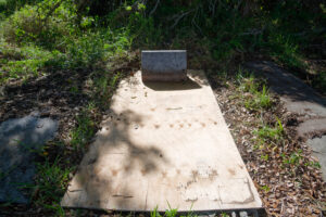 A damaged grave belonging to Mother Mary B. Wilson covered by plywood.