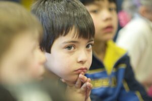 Close-up of a grade school student with a thoughtful expression.