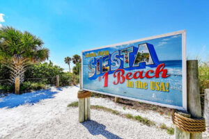 A colorful billboard advertising Siesta as the "#1 Beach in the USA!".