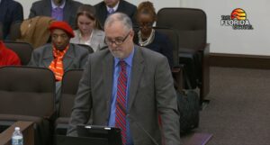 Jon Brown standing to speak at a committee meeting.