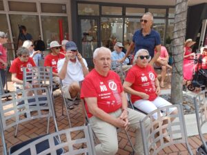 A crowd of people wearing red shirts that oppose "the Skyscraper On Palm Ave".