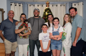 A family photo featuring Douglas Dixon, Jo Ann Collison and others in front of a Christmas tree.