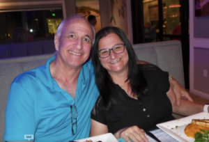 Douglas Dixon and Jo Ann Collison smiling and hugging.