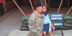 Kristina Sargent in uniform holding her young daughter.