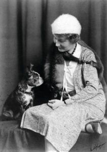 Black and white photo of Marie Selby with a dog.