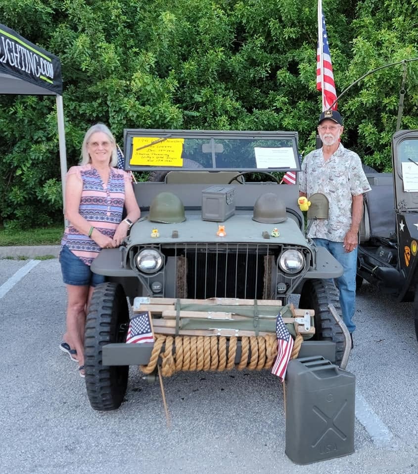 Carla and Arnold Popp posing with a 1941 Willys MB jeep.