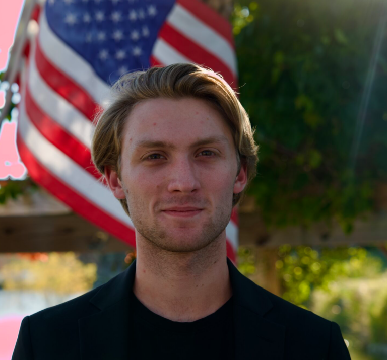 Cam Bedinghaus in front of a U.S. flag.