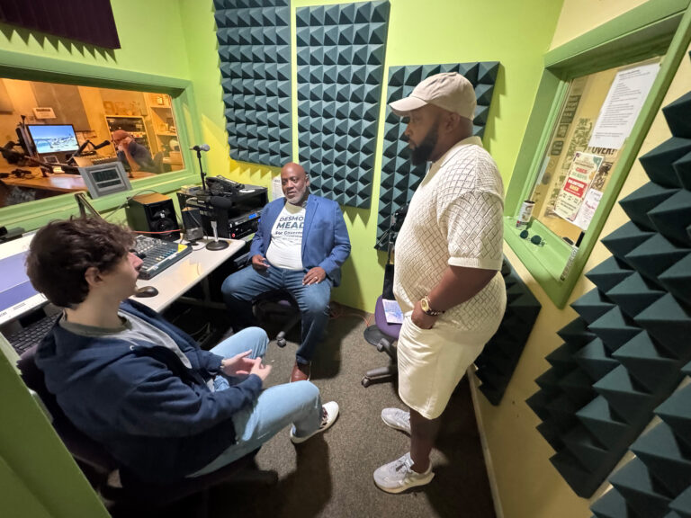 Jackson Rothman and Ed James III interviewing Desmond Meade in a sound studio.