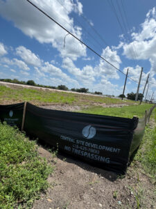 A Central Site Development banner that reads "No Trespassing" by a fenced-off construction site.