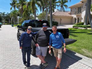 James Peel and two other Longboat Key Roofing employees smile for a photo.