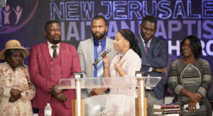Jean Tannulis and others standing on stage at a church event.