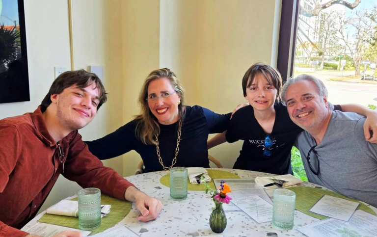 Rob Rominiecki at a table with three family members, all smiling.
