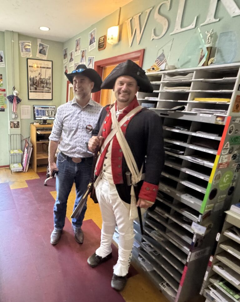 Eddie Speir in the WSLR lobby beside someone in a revolutionary war uniform.