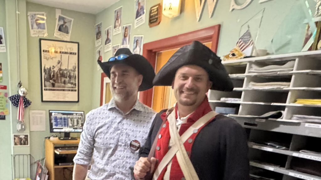 Eddie Speir in the WSLR lobby beside someone in a revolutionary war uniform.