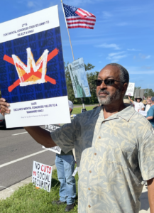 Glenn Pearson holding a No Kings protest sign.
