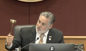 Joe Neunder at a commission meeting holding a gavel.