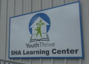 Sign that reads "Youth Thrive SHA Learning Center".