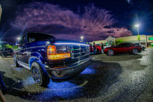 An F-150 with blue underglow lights.
