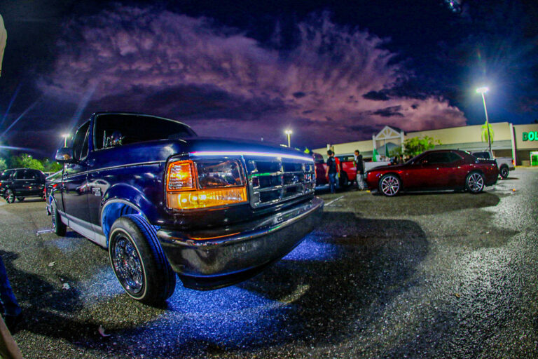 An F-150 with blue underglow lights.