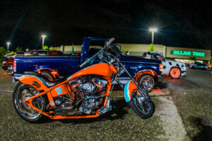 A vibrant orange and aqua motorbike with a number 13 painted on it.