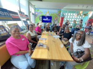 A group of Angie Nixon's supporters smiling and sit at a booth at the Mellow Mushroom.