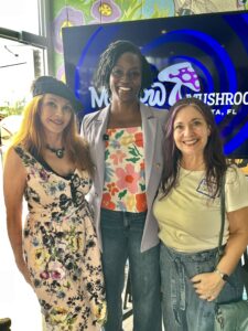 Angie Nixon smiling with her arms around two supporters.
