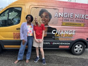 Angie Nixon and a supporter stand next to an Angie Nixon for U.S. Senate campaign van.