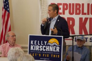 Kelly Kirschner addresses a crowd in front of a "Republicans for Kirschner" banner.