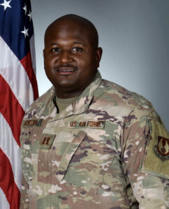 Victor Johnson in uniform next to a U.S. flag.