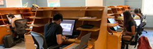 Students work on large drawing tablets in a classroom.