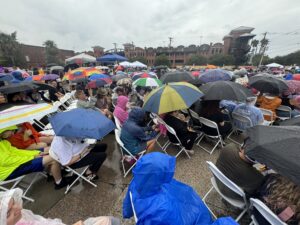 A full crowd of people with umbrellas at an event.