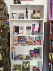 Books including "Highly Successful Small Habits," "Secrets Kept: Walking By Faith," "Mighty Kings, "Why Do Good Girls Cry?" and "Push the Button" on display on a shelf.