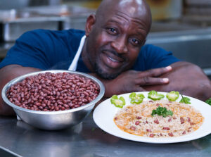 Wilkinson Sejour posing next to two plates of food.