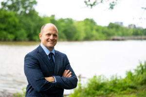 Jose Javier Rodriguez smiling in front of a body of water.